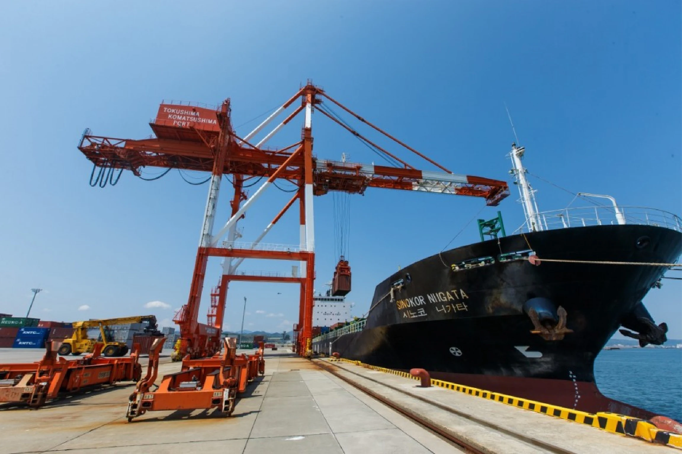 コンテナ船にクレーンで積載する写真